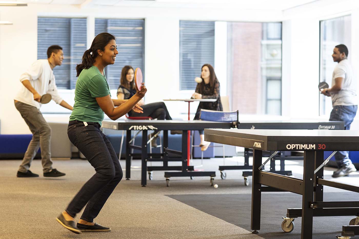 Employees take a break and enjoy a game of table tennis